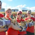 Volunteers show off potatoes they've gathered