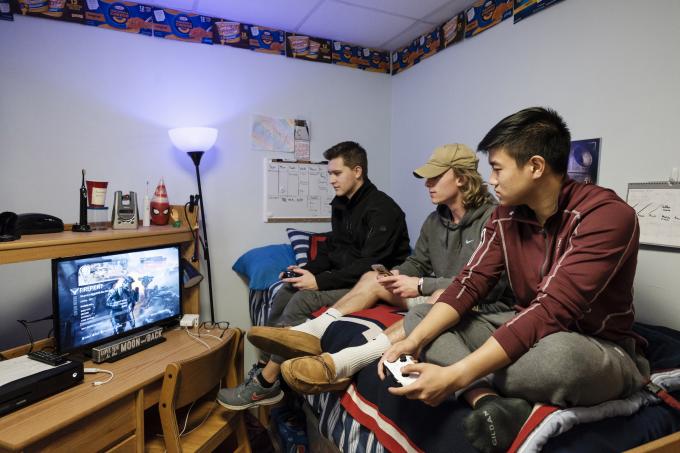 Students playing video games in dorm room