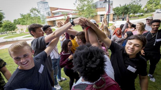 Students join hands in the quad