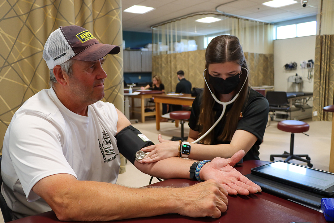 A DPT student checks a patient's blood pressure.