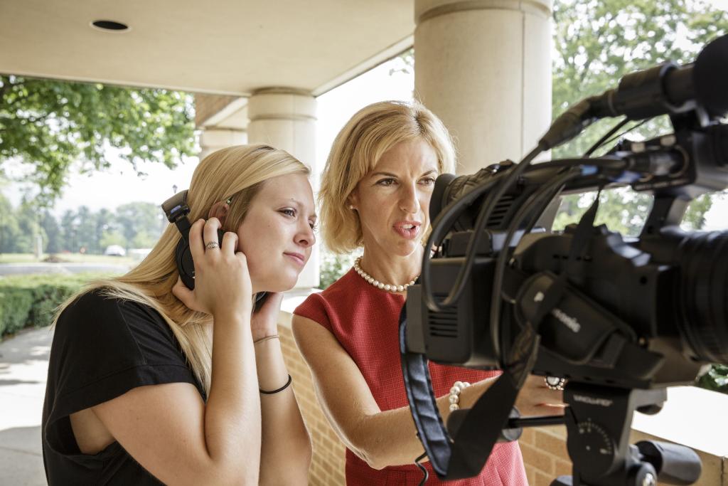 Professor teaches student to use video equipment
