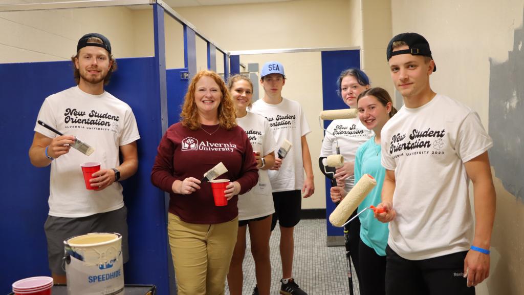 Students and Alvernia President Glynis A. Fizgerald paint a bathroom at Reading High School