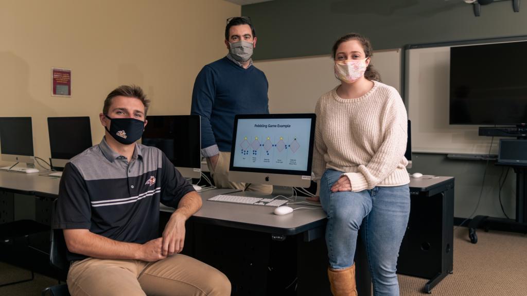 Luke Fagley ’22 (left) and Andrea Potylycki ’21 (right) showcase their S.U.R.F. project with Assistant Professor of Mathematics Matt Prudente, Ph.D. (center).