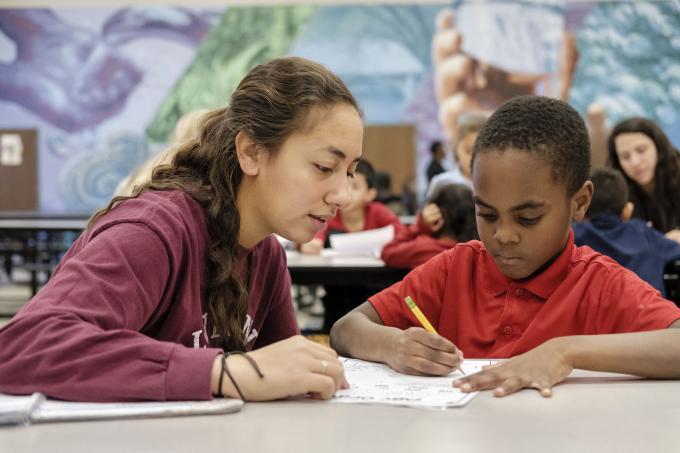 Volunteer helps child with homework
