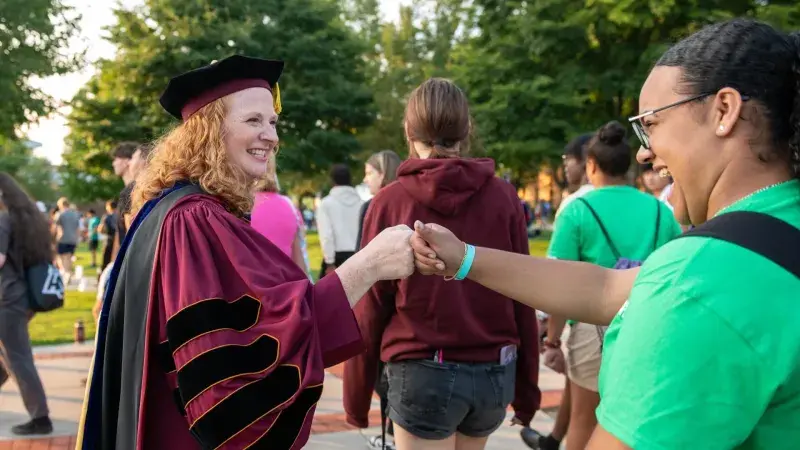 Alvernia University President Glynis A. Fitzgerald greets students during Luminary Ceremony