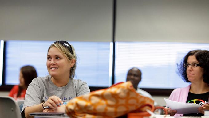A female student smiles in an adult education class.