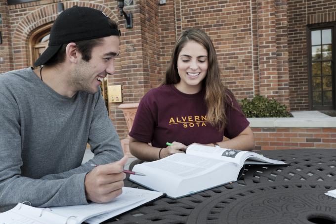 Students work together in front of Francis Hall.