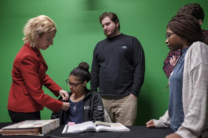 Dr. Jodi Radosh places a student's microphone.