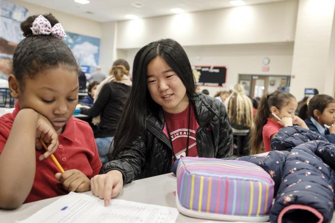 Volunteer helps child with homework