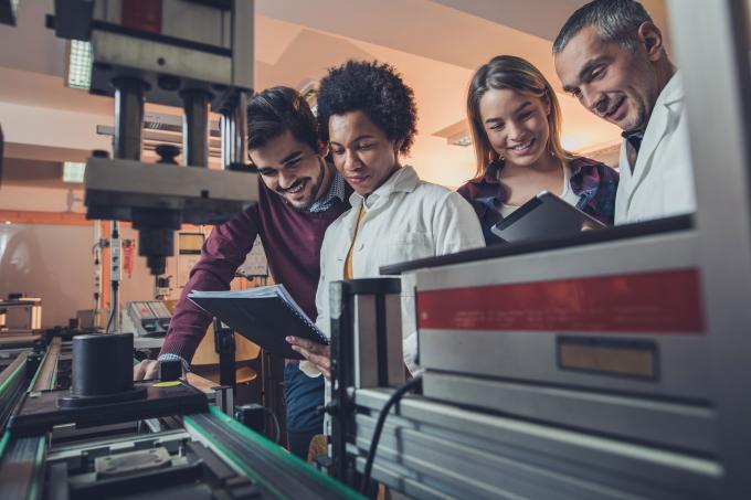 Three Engineering Students in a Lab with a Professor