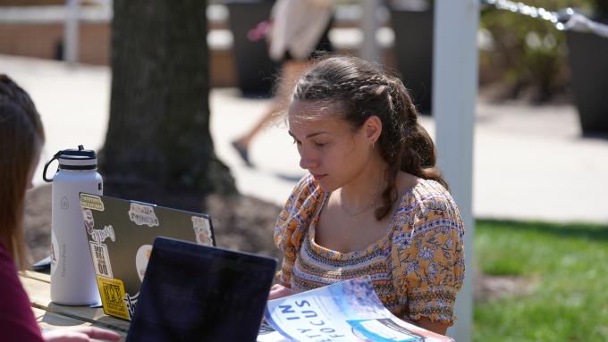 A student studies outdoors on Alvernia's campus.
