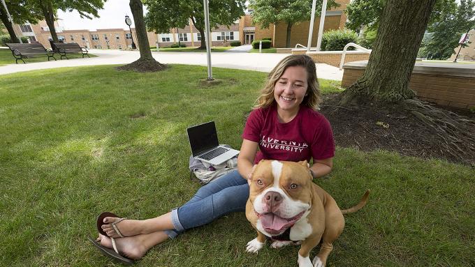 Student with dog on campus