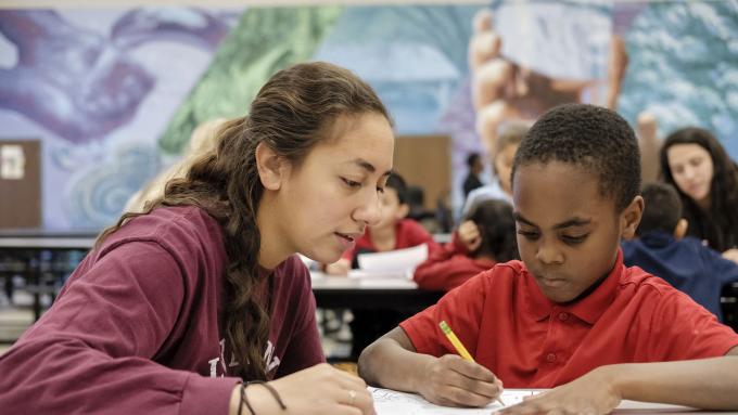 Volunteer helps child with homework