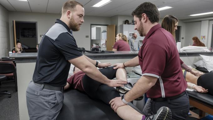 Clinical instructor, John Anthony Rossi, demonstrating proper stretching technique with athletic training student.