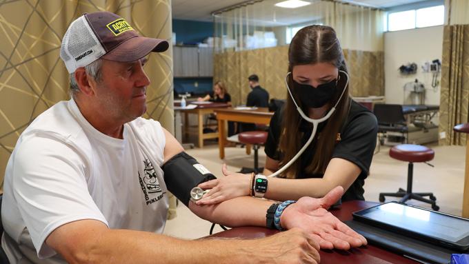 A DPT student checks a patient's blood pressure.