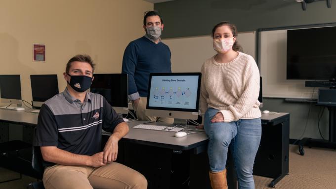 Luke Fagley ’22 (left) and Andrea Potylycki ’21 (right) showcase their S.U.R.F. project with Assistant Professor of Mathematics Matt Prudente, Ph.D. (center).