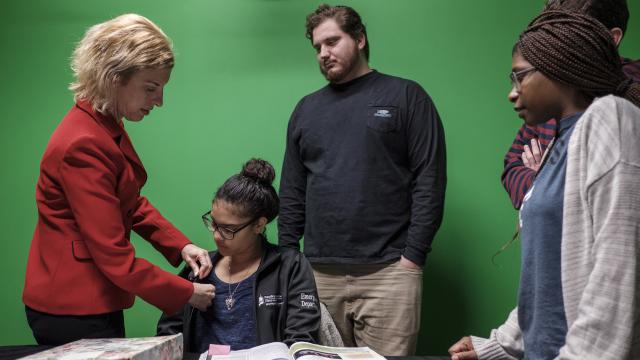 Dr. Jodi Radosh places a student's microphone.